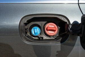 Fuel filler flap open with red diesel cap and blue adblue, the fuel filler caps are closed.